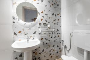 a white bathroom with a sink and a mirror at ATHENAIS CENTRAL in Litochoro