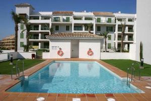 basen przed dużym budynkiem w obiekcie ATICO EN SOTOGRANDE w mieście Sotogrande