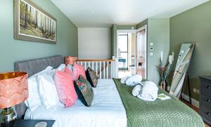 una camera da letto con letto, lenzuola e cuscini bianchi di Fresh and Luxurious Stylish, Grade II Listed Church conversion with Workspace, centrally located a Stow on the Wold