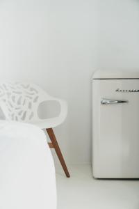 a white stool next to a white refrigerator at Blue Sea Villa in Serifos Chora