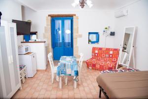 a living room with a table and a blue door at Xenia - Il Vicoletto delle Dee in Syracuse