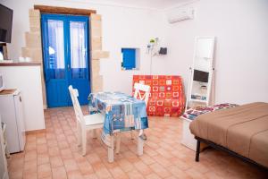 Pokój ze stołem i krzesłami oraz niebieskimi drzwiami w obiekcie Xenia - Il Vicoletto delle Dee w Syrakuzach
