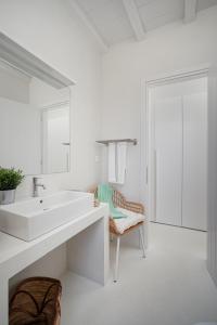 a white bathroom with a sink and a mirror at Blue Sea Villa in Serifos Chora