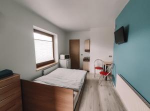 ein kleines Schlafzimmer mit einem Bett und einem Schreibtisch in der Unterkunft K-Town - Cozy Apartment Near the City Center in Kaunas
