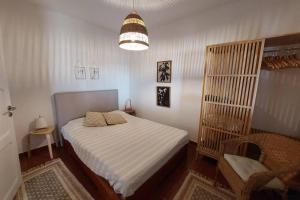 a small bedroom with a bed and a chair at Casa do Vale in Vale de Água