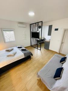 a bedroom with two beds and a flat screen tv at Muki apartments in Surčin