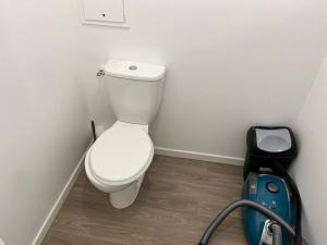 La salle de bains est pourvue de toilettes et d'une valise bleue. dans l'établissement T3 65 m2 avec parking 15 mns Paris by immo kit bnb, à Gagny