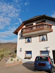 a car parked in front of a house with a balcony at Melanies Wohlfühlort in Bruttig-Fankel