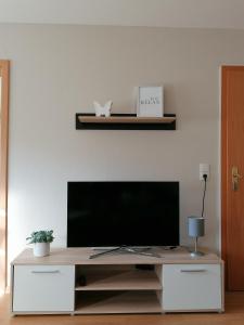 a living room with a television on a white wall at Melanies Wohlfühlort in Bruttig-Fankel