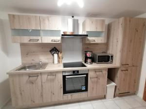 a kitchen with wooden cabinets and a sink and a microwave at Melanies Wohlfühlort in Bruttig-Fankel