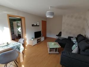 a living room with a black couch and a table at Melanies Wohlfühlort in Bruttig-Fankel