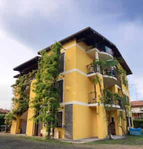 żółty budynek z rosnącymi roślinami w obiekcie Draisina Bike Apartments DUE w mieście Oleggio Castello