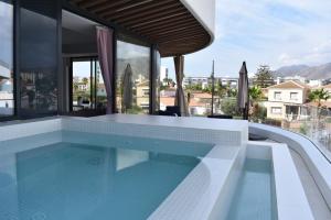 basen z widokiem na dom w obiekcie Luxury complex beachfront apartment, infinity pool, sauna, gym and large terrace w mieście Torremolinos