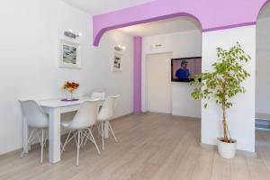 - une salle à manger avec une table, des chaises et une télévision dans l'établissement Sunny 2-Bedroom Maisonette Varna & Parking, à Varna