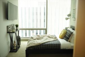 a bedroom with a bed and two large windows at Luxury Living w/View and Parking in Los Angeles