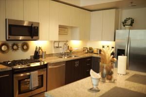a kitchen with white cabinets and a stainless steel refrigerator at Luxury Living w/View and Parking in Los Angeles
