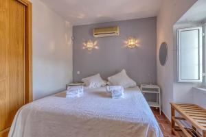 a bedroom with a white bed with two towels on it at Casa Perola -ocean view cottage in Carvoeiro