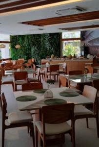 a dining room with tables and chairs in a restaurant at Beautiful studio Muro Alto mana beach in Ipojuca