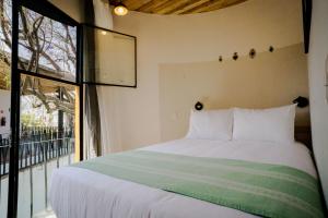 a bedroom with a bed and a large window at Hotel con Corazón in Oaxaca City