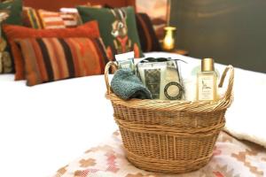 a basket sitting on a bed with medicines and soap at Luxury Farm Stay at The Lodge at Wolf Pine Hollow in Hancock