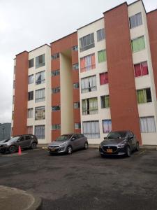 tres autos estacionados en un estacionamiento frente a un edificio en SANDY APARTAMENTO en Santa Rosa de Cabal