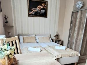 a bedroom with two beds and a painting on the wall at Puszek in Ustka