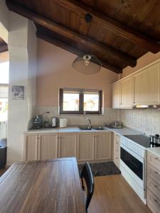 North Chalet في أراخوفا: مطبخ مع طاولة خشبية وسقف خشبي