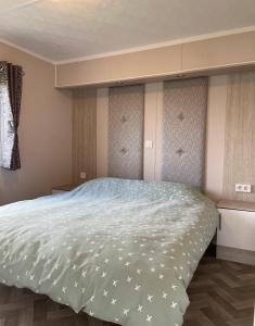 a bedroom with a large bed with stars on it at Chalet direct aan Waddenzee in Westerland