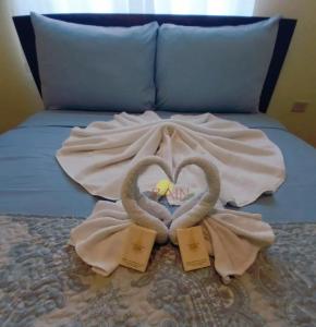 a bed with two swans made to look like hearts at Highend resort in Buccoo