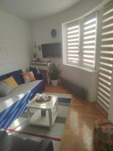 un soggiorno con divano blu e tavolo di ANKA apartman a Smederevo