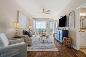 a living room with a couch and a tv at Phoenix Vll 1102 in Orange Beach