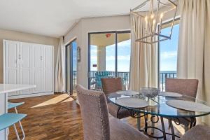 a dining room with a table and chairs and a balcony at Phoenix Vll 1102 in Orange Beach