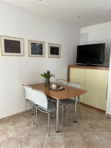 einen Esstisch mit Stühlen und einen Flachbild-TV in der Unterkunft Apartments Marinovic in Brzac