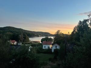 a view of a house and a lake at sunset at Villa Angelica in Ljungskile