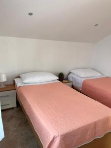 two beds sitting next to each other in a room at Apartments Marinovic in Brzac