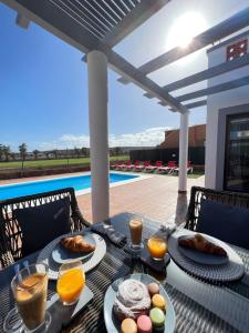 a table with food and drinks on a patio at Villa Eva - New to the market, fully refurbished licensed villa - private pool in Caleta De Fuste