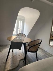 1 mesa y 2 sillas en una habitación en appartement catimini, en Dijon