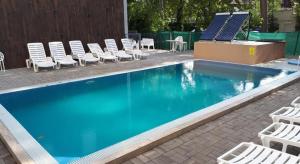 a swimming pool with lounge chairs and a solarium at Belu Apartman in Balatonlelle