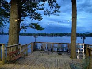 a wooden deck with a table and chairs on the water at Shafer Lakeside Resort in Monticello