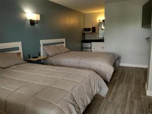 two beds in a hotel room with a kitchen at Shafer Lakeside Resort in Monticello