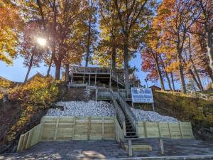 a staircase leading up to a deck in a park with trees at Shafer Lakeside Resort in Monticello