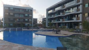 ein großes Schwimmbad vor einem Gebäude in der Unterkunft Muro Alto Mana Beach Experience Apartamento B104 in Ipojuca