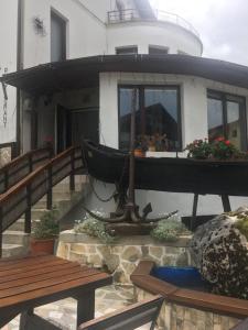 dom z łodzią na ganku z ławkami w obiekcie Ancora w mieście Predeal