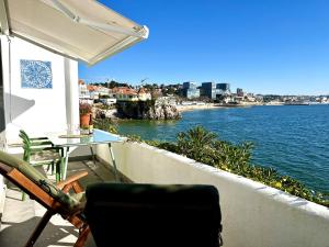 卡斯凱什的住宿－Ocean dream apartment，阳台配有桌子,享有水景