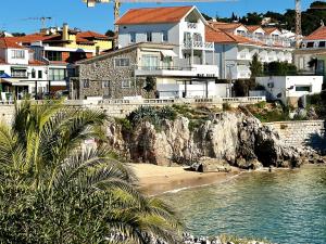 a group of houses on a beach next to the water at Ocean dream apartment in Cascais