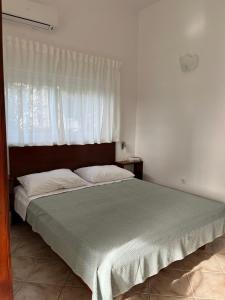 Schlafzimmer mit einem großen Bett und einem Fenster in der Unterkunft Apartments Marinovic in Brzac