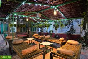a group of benches in a room with plants at Gir Pride Resort in Sasan Gir