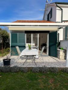 a patio with a table and chairs in front of a house at Apartments Marinovic in Brzac