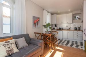 a living room with a couch and a kitchen at TikLiving in Ericeira