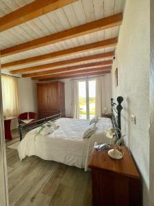 1 dormitorio con 1 cama grande y suelo de madera en San Leonardo Country House, en Calangianus